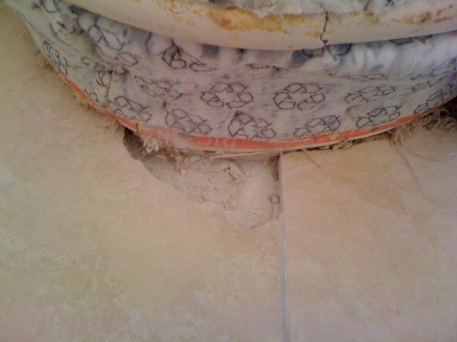 A large hole in a cross cut travertine floor tile