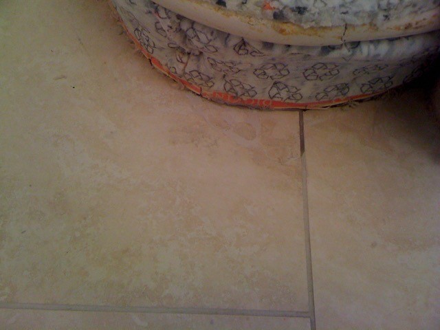A hole repaired in a Travertine Floor Tile with resin filler