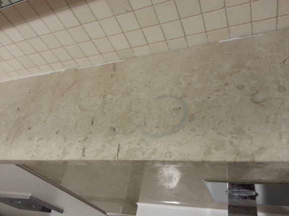 Etch mark on a marble shelf caused by a toilet cleaning agent