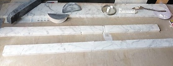 DAMAGED PIECES OF THE MARBLE FIREPLACE WERE REPAIRED WITH A WHITE RESIN ADHESIVE