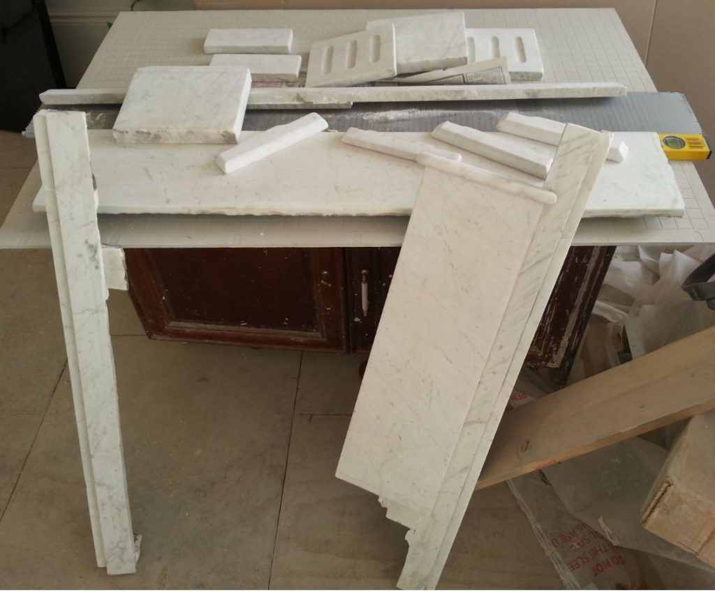 THE CLEANED, SANDED AND REPAIRED PIECES OF THE MARBLE FIREPLACE