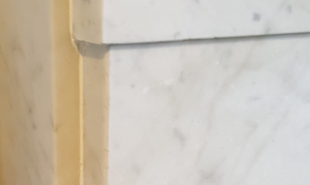 JOINTS OF THE MARBLE FIREPLACE ARE FILLED IN WITH WHITE GROUT
