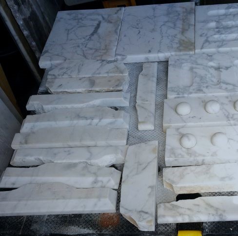THE PIECES OF THE MARBLE FIREPLACE ARE SANDED AND THE LARGER CHIPS ARE REPAIRED WITH A WHITE RESIN FILLER