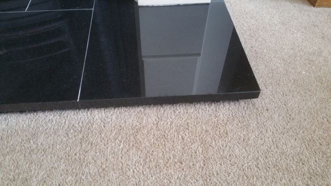 Chipped black granite hearth repaired with a resin