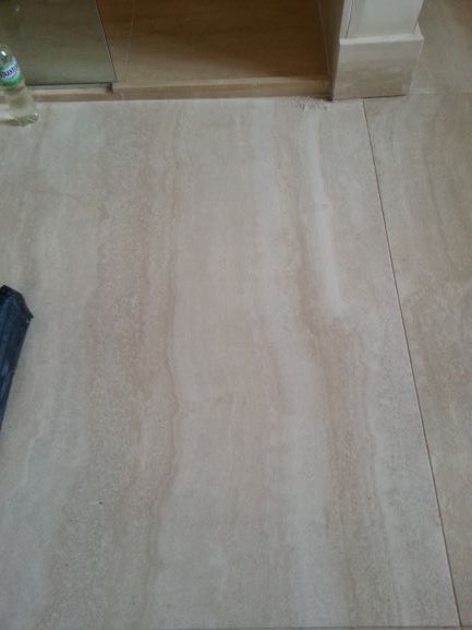 A cracked bathroom Travertine floor tile after being repaired