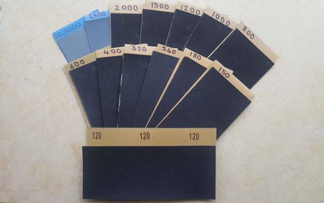 Assortment of silicone carbide sanding paper used for removing scratches from marble